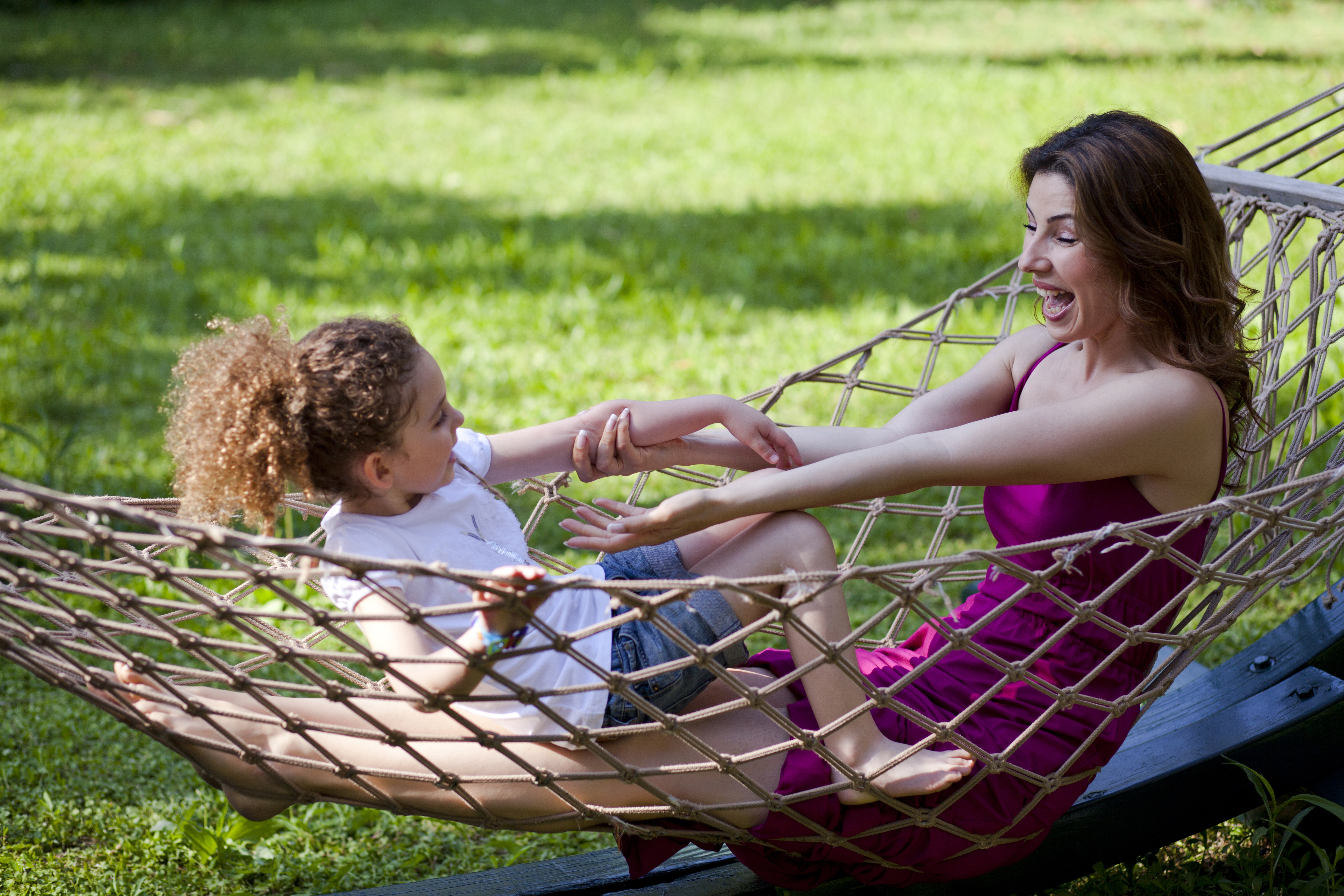 Mother and daughter are enjoying on hammock at park